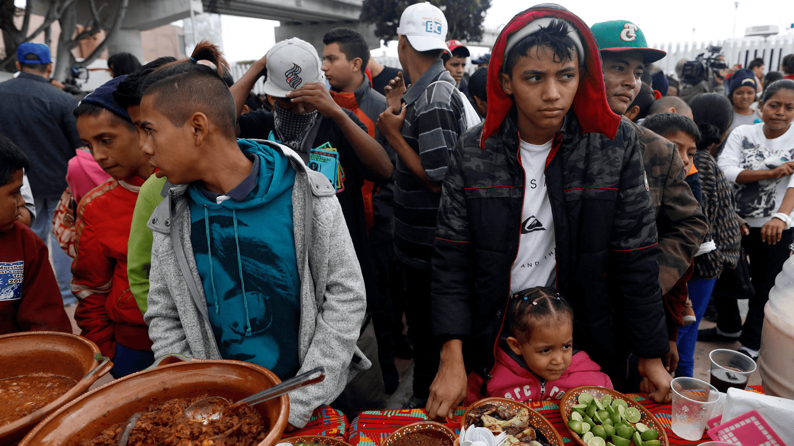 Members of a caravan of migrants from Central America line up to receive food near the San Ysidro checkpoint as the first fellow migrants entered US territory to seek asylum on Monday, in Tijuana, Mexico, April 30, 2018.