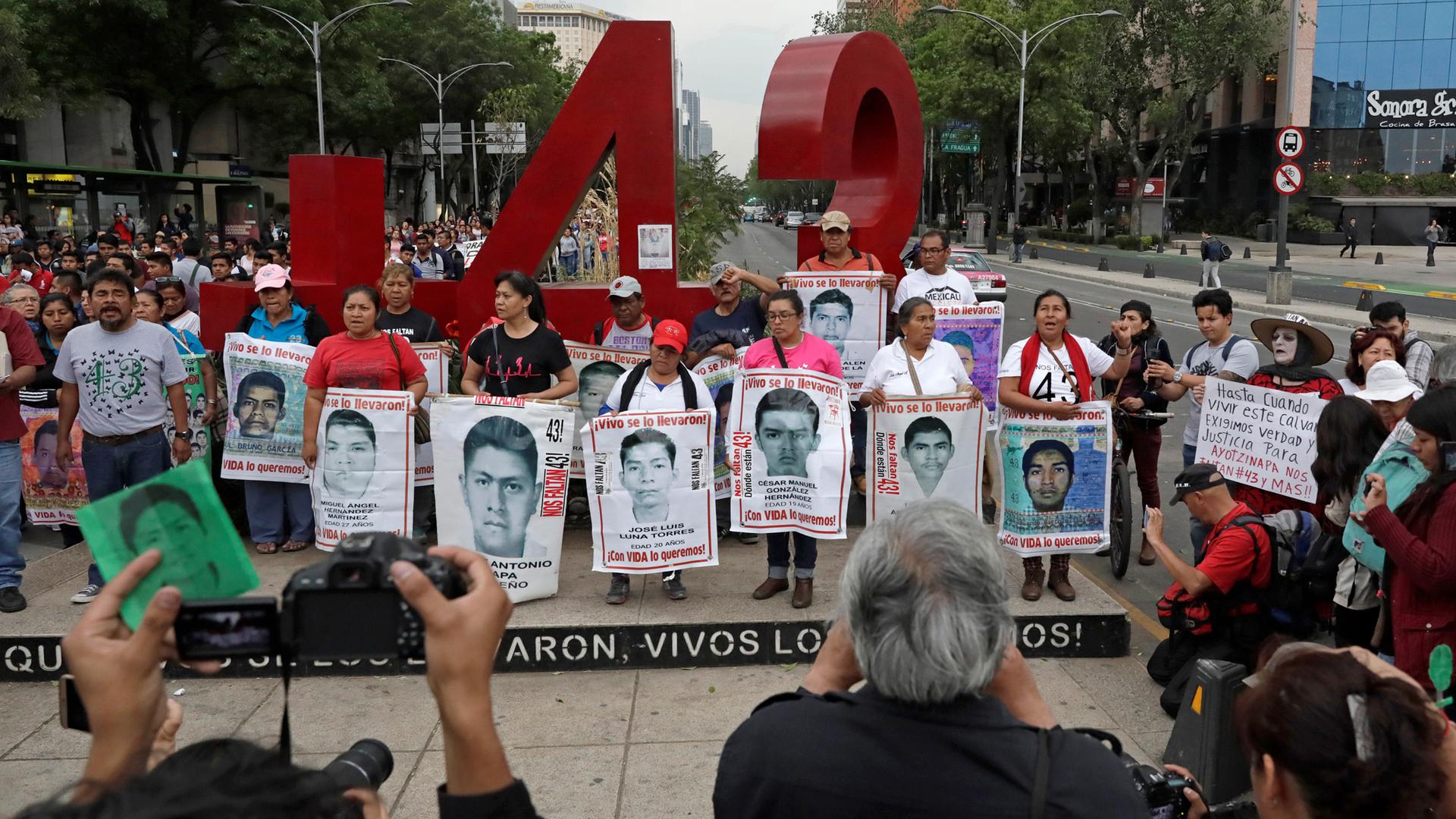 Relatives pose with images of some of the 43 missing Ayotzinapa College Raul Isidro Burgos students in Mexico City.