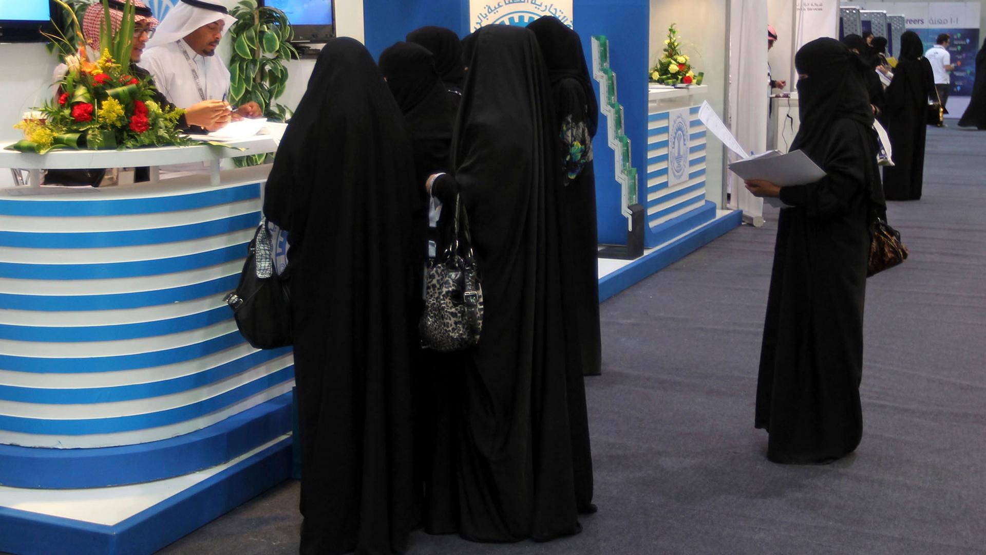 Saudi Arabian women, seeking a job, talk with recruiters during a job fair in Riyadh.