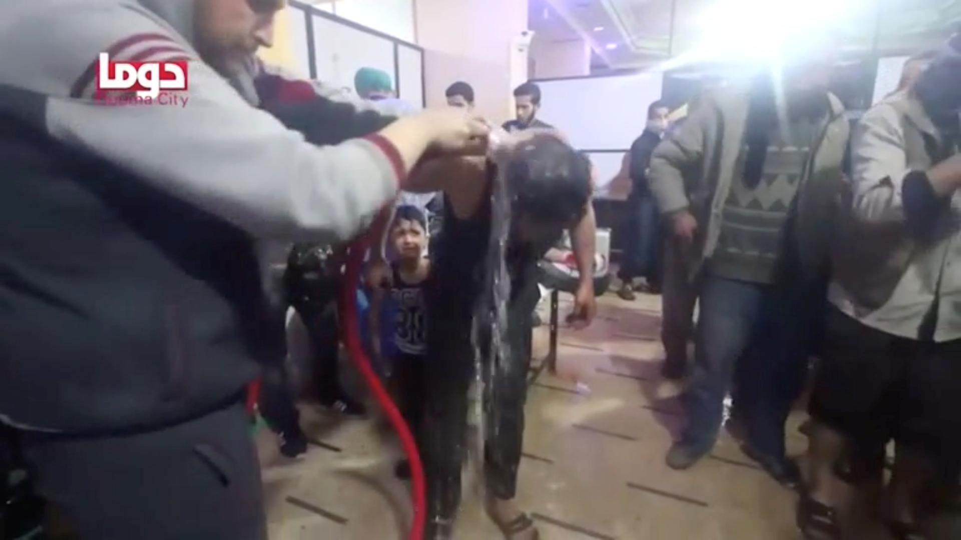 A man is washed following alleged chemical weapons attack, in what is said to be Duma, Syria in this still image from video obtained by Reuters on April 8, 2018.