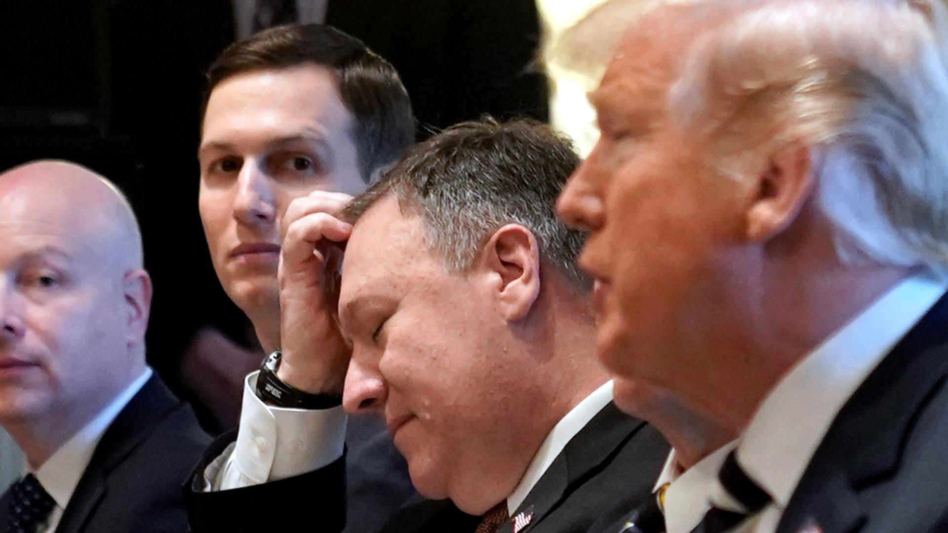 CIA Director Mike Pompeo sits center in the in-between President Donald Trump in the near ground and Jared Kushner in the background.