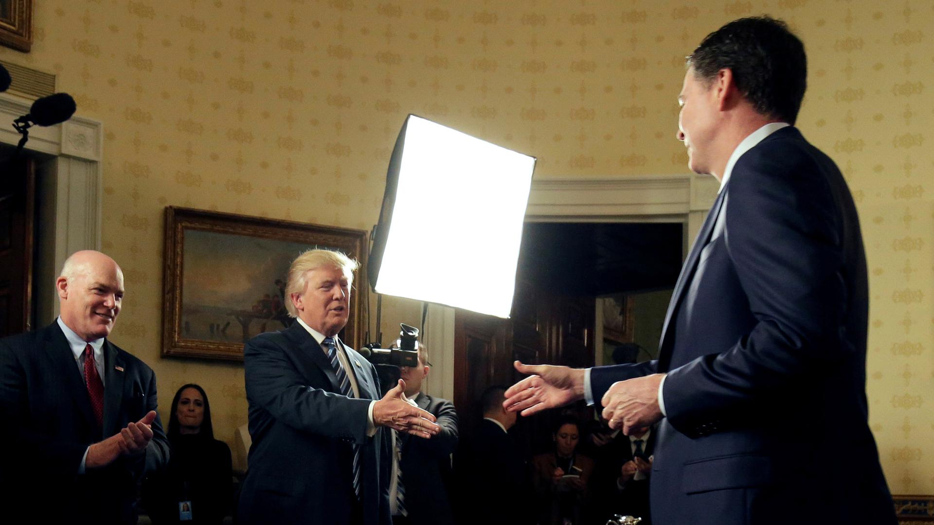 President Donald Trump greets Director of the FBI James Comey as Director of the Secret Service Joseph Clancy (L), watches at the White House.