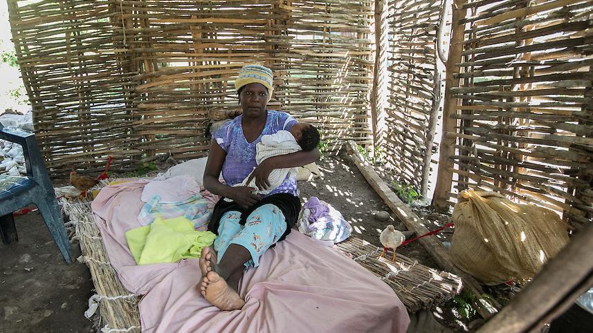 Christella Saintime sits with her 6-week-old baby, several feet from the Dominican Republic. She fled to Haiti when she was 5 months pregnant.