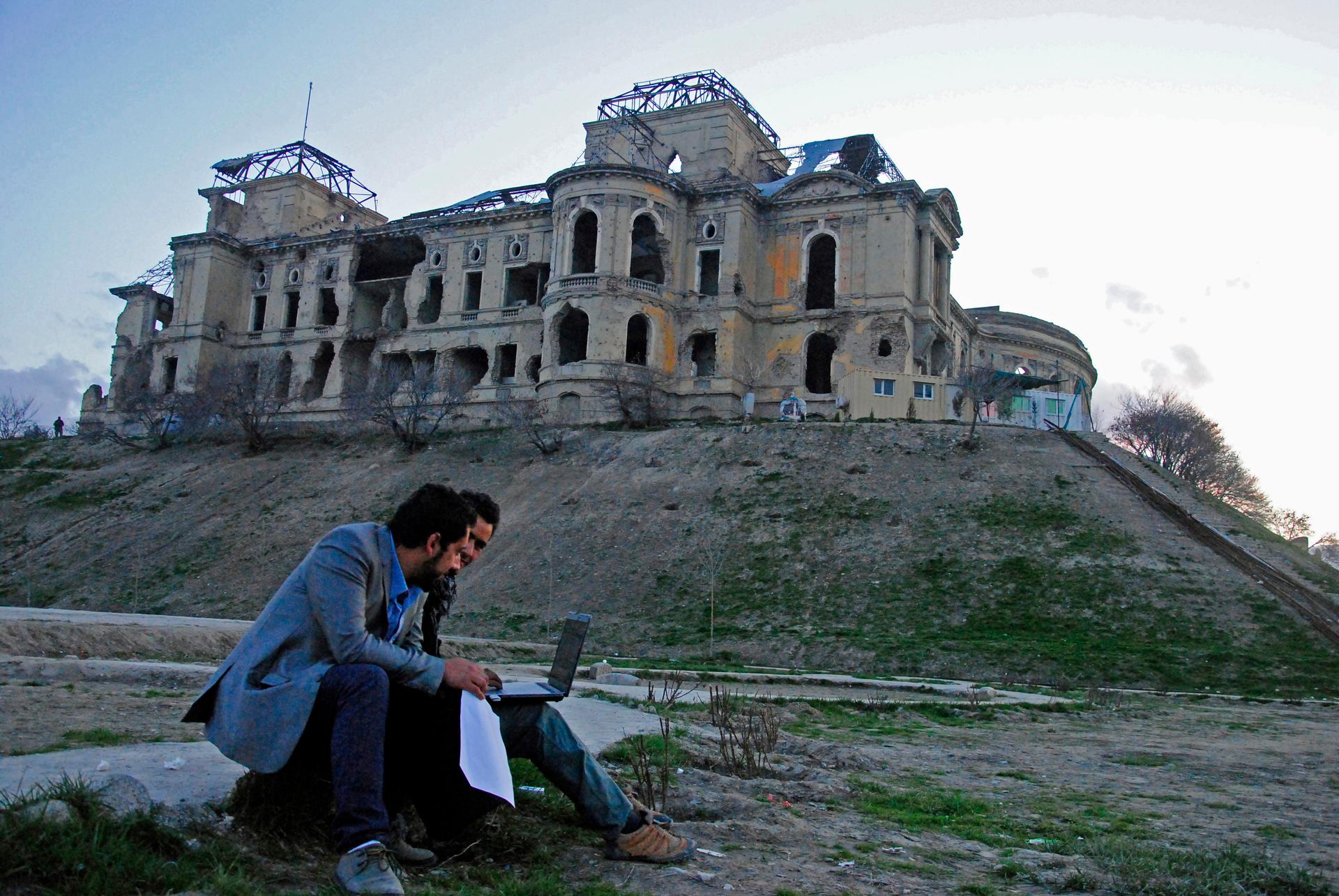 Youngsters surf the Internet near the ruined Darul Aman Palace, which was built in the 1930s. Only 5.5 percent of Afghan youths have access to the Internet, but technology played a role in connecting youth during last year's presidential elections. 