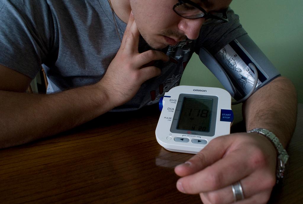 A man checks his own blood pressure using an at-home machine. Researchers hope to expand the range of at-home medical care with new tests and devices.