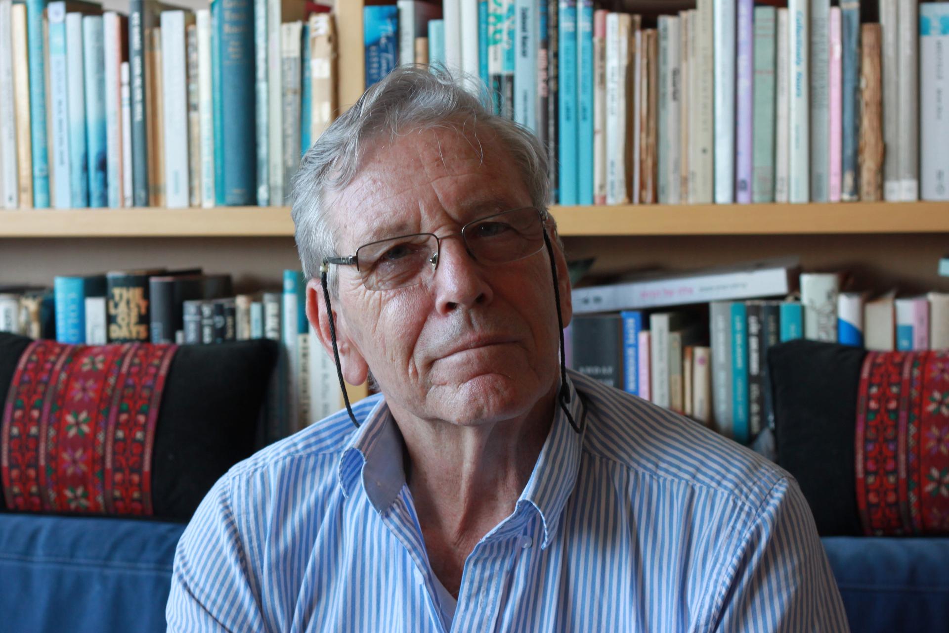 Amos Oz in his Tel Aviv apartment. His bestselling memoir, "A Tale of Love and Darkness," is on the bookshelf behind him, translated into more than two dozen languages.