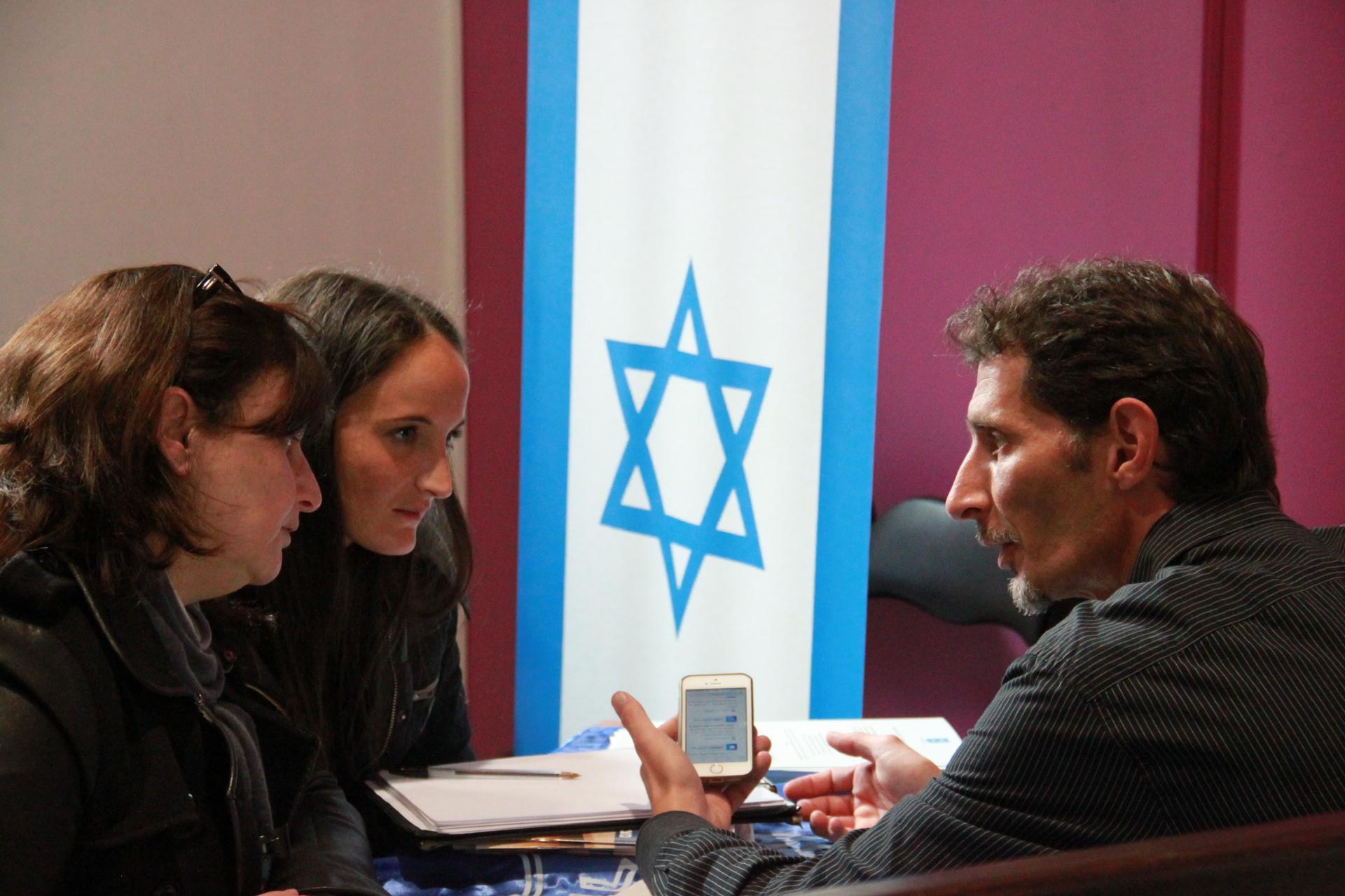 An Israeli government representative discusses Israeli immigration with prospective Jewish immigrants at an immigration expo in Paris.