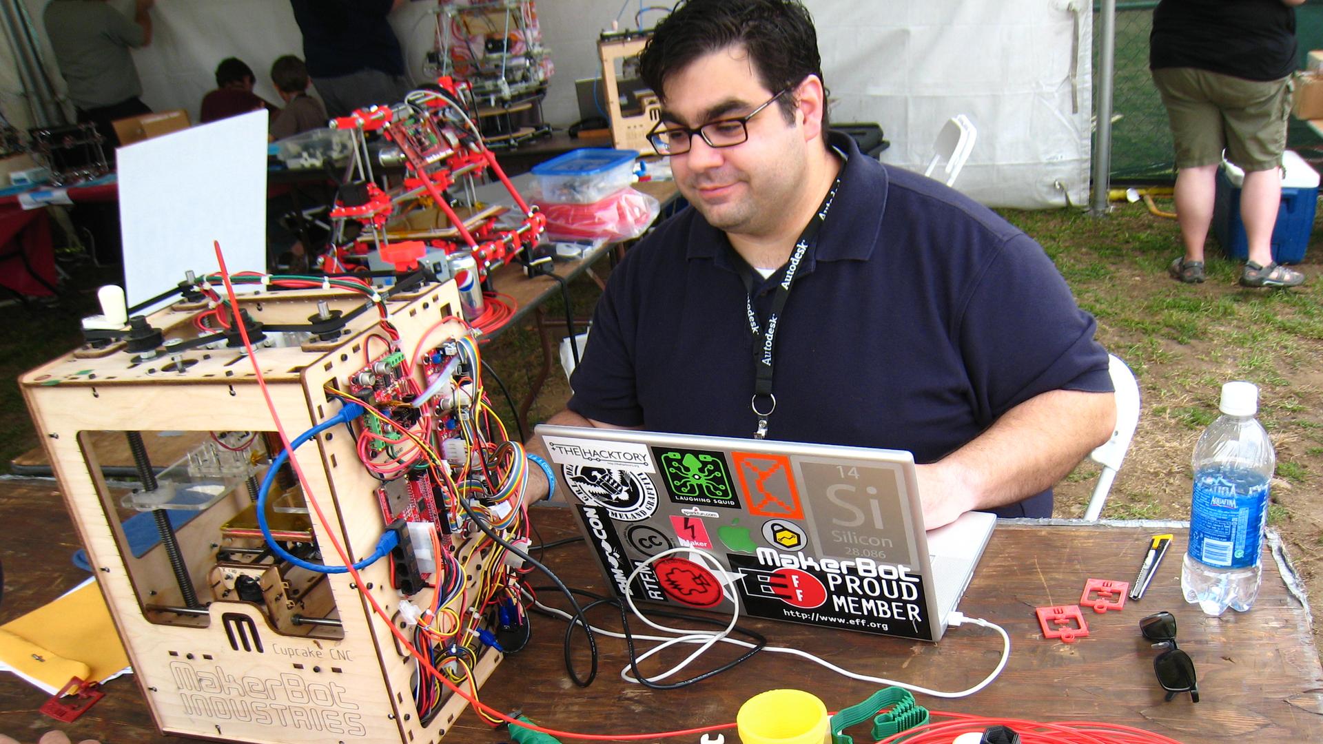 A man operates a 3D printer at a 2010 Maker Faire, a gathering for maker movement enthusiasts, in New York City.