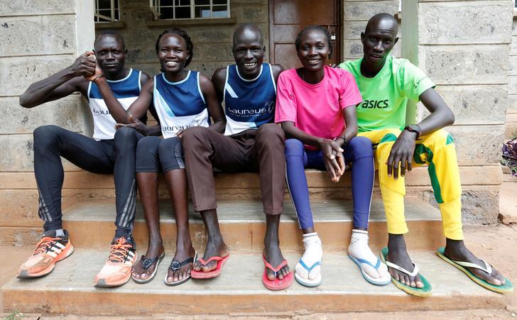 Five athletes from South Sudan who will be participating in the Summer 2016 Olympics sit beside each other on a short set of steps near their training grounds in Nairobi