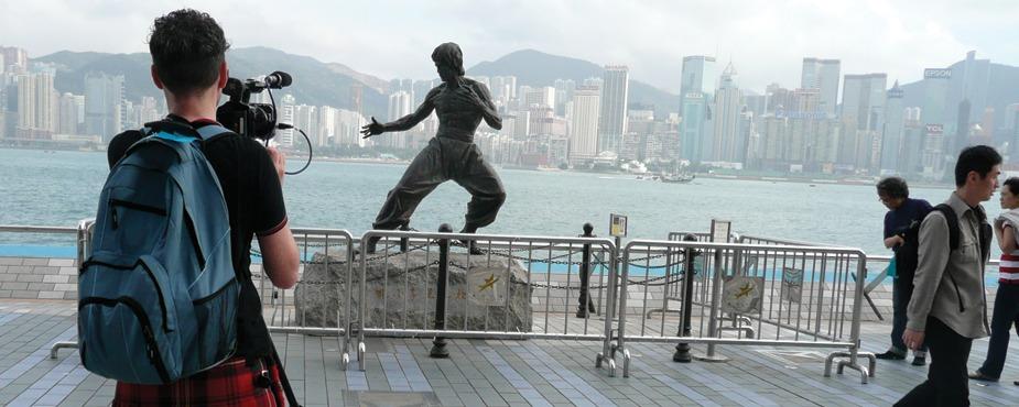Filmmaker Mark Cousins during this six-year filming of The Story of Film, shooting the skyline of Hong Kong with a statue of hometown hero and martial artist Bruce Lee in the foreground. 