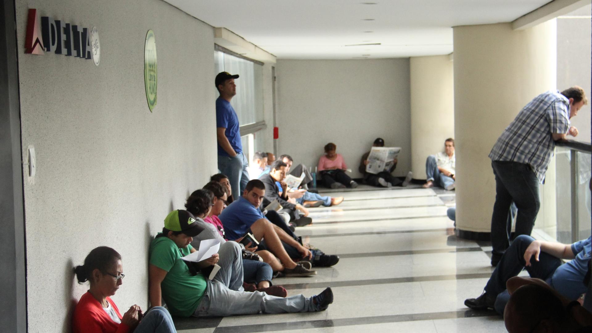Dozens of desperate travelers wait in front of a Delta airlines ticket office at dawn in Caracas, Venezuela.