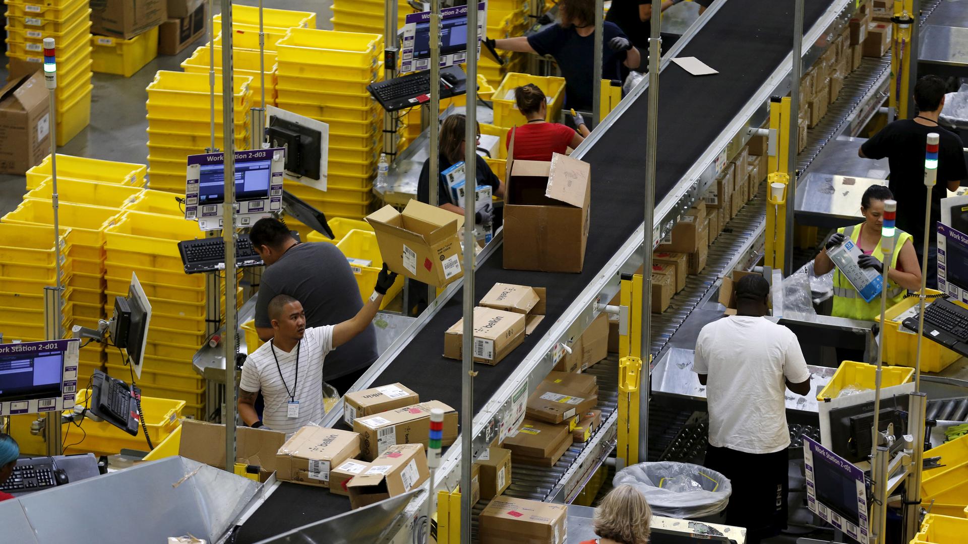 Workers sort arriving products at an Amazon Fulfilment Center in Tracy, Calif.