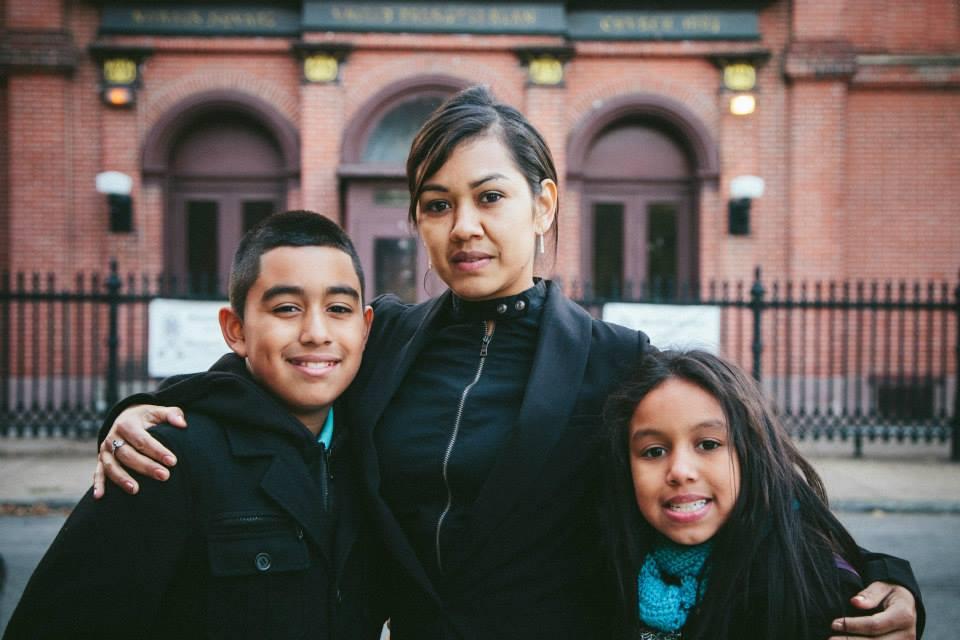 Angela Navarro and her two children stand outside the church where they've been living since mid-November. 