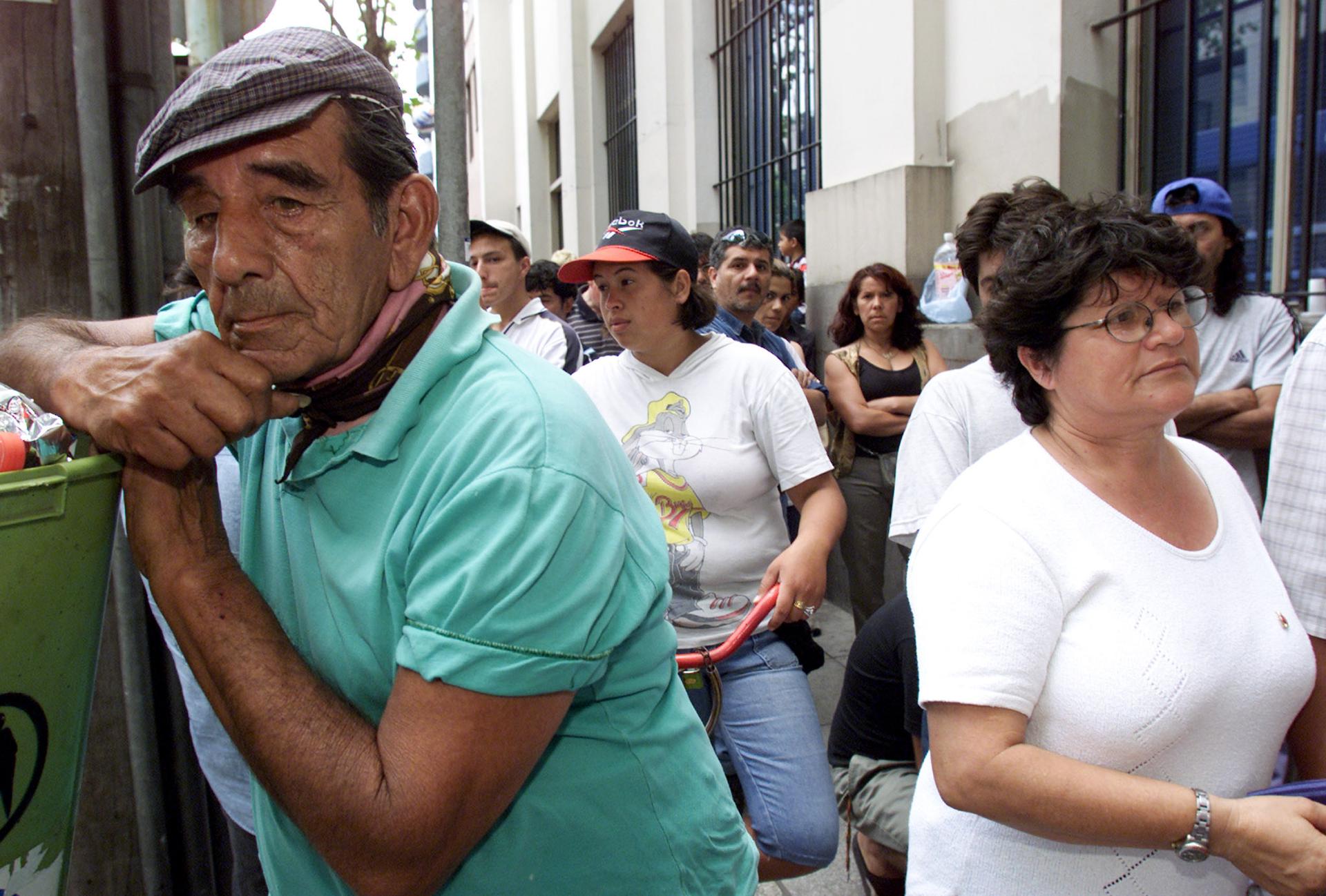 Unemployed Argentines and workers line up outside the Banco de la Nacion in Buenos Aires trying to collect their money, December 21, 2001. Argentina would default on its sovereign debt days later. 