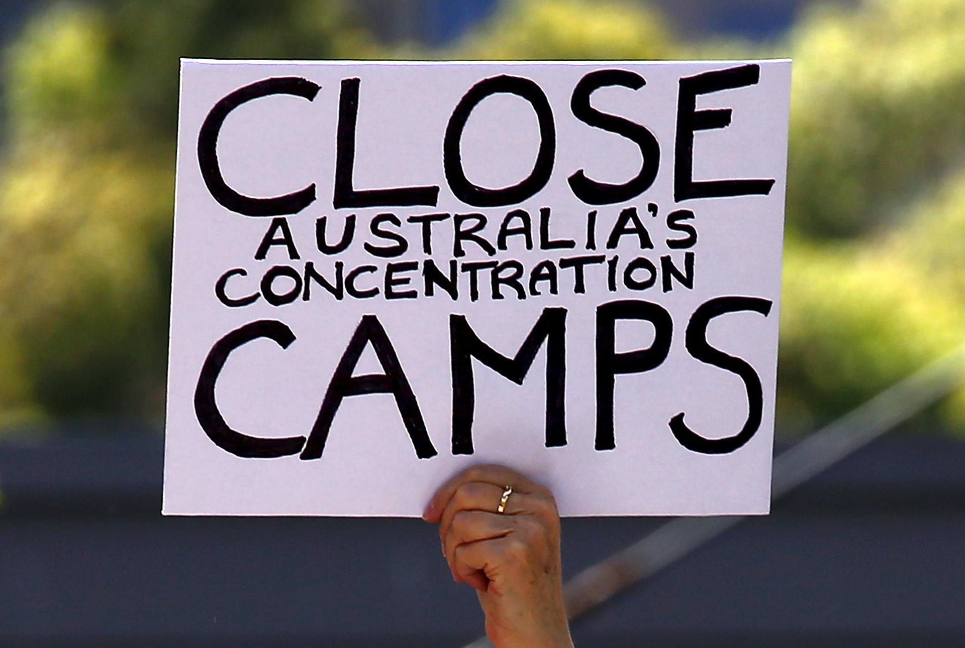 A protester holds a placard during a rally in support of refugees currently being held in Australia's offshore detention camps in Nauru and Papua New Guinea. Many Australians want the 1,250 refugees being held at the two camps to be allowed to live in Aus