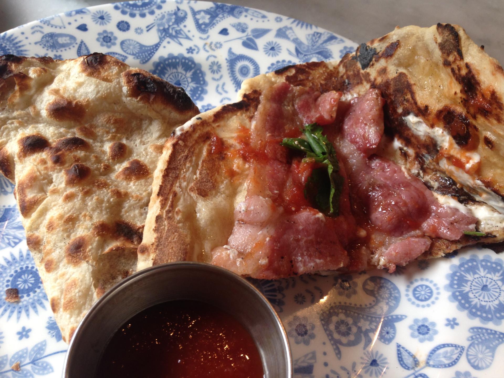 Bacon wrapped with naan bread at Dishoom cafe in London