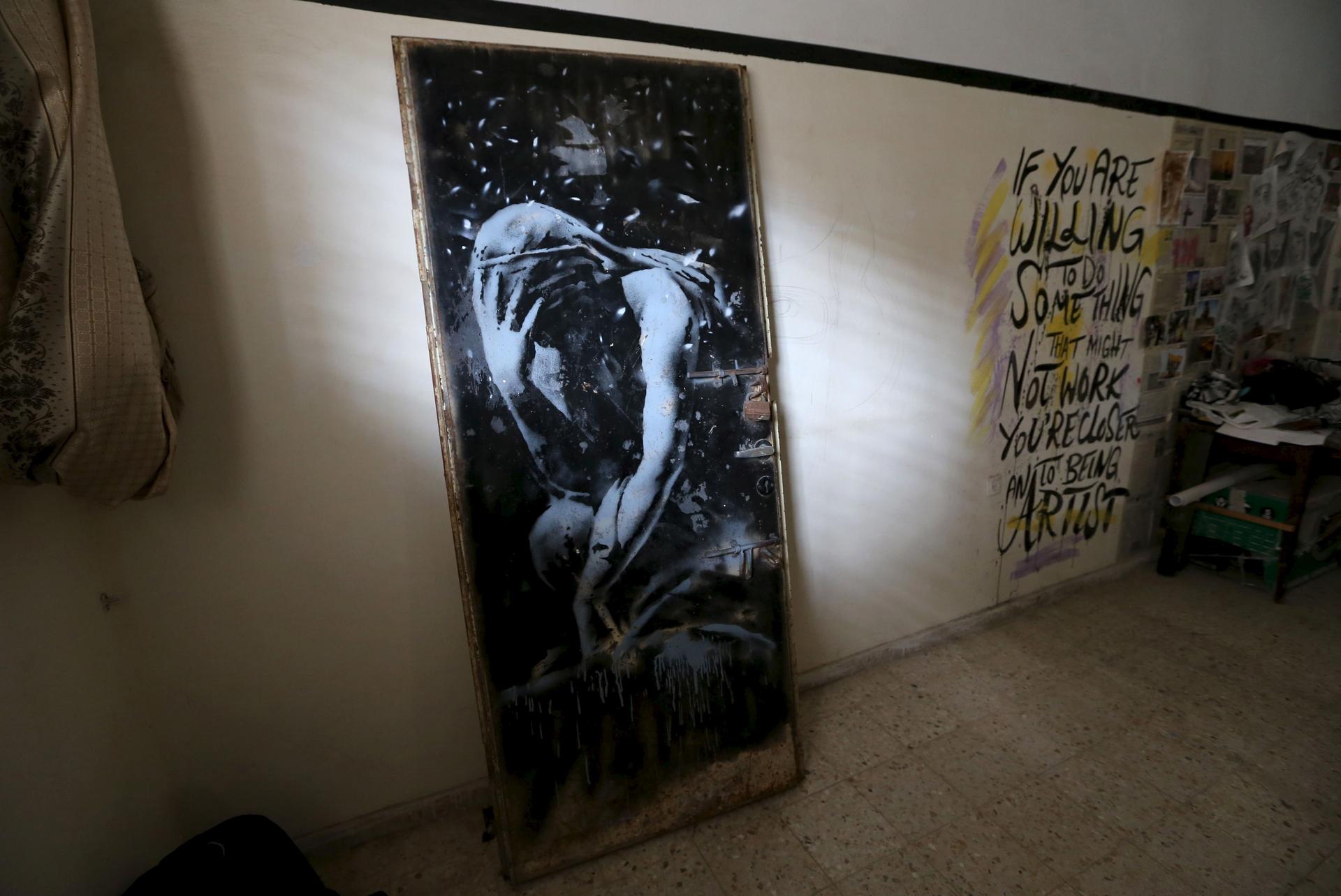 The door of a destroyed house, painted by British street artist Banksy, is seen here inside the gallery of a local Palestinian artist.