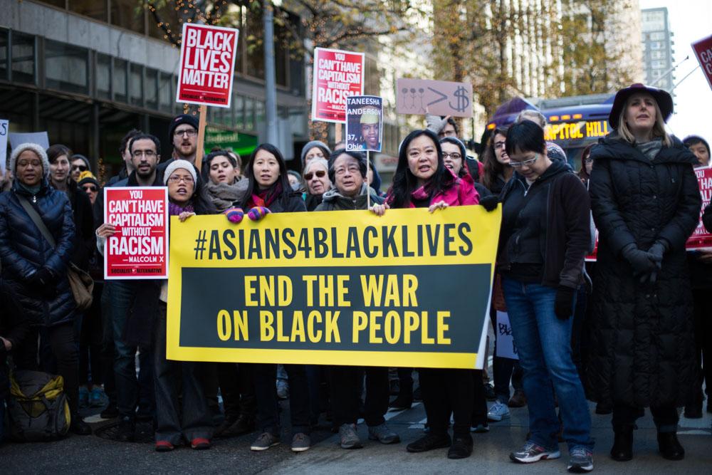Protesters show solidarity with Black Lives Matter by holding a sign on the street