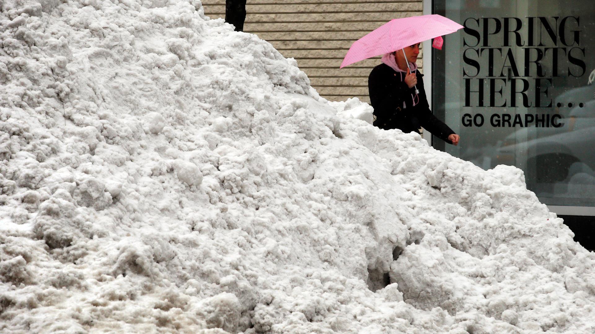 "Spring is coming" — A pedestrian walks past a pile of snow in Boston.