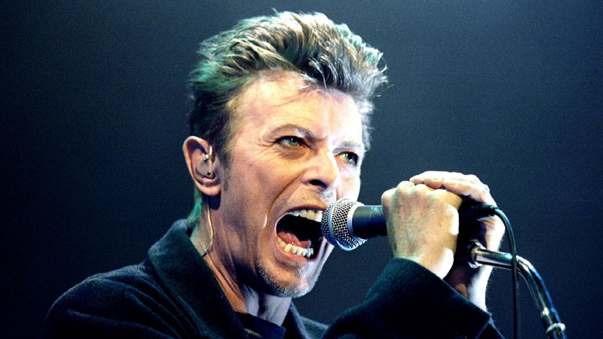 British Pop Star David Bowie screams into the microphone as he performs on stage during his concert in Vienna February 4, 1996.