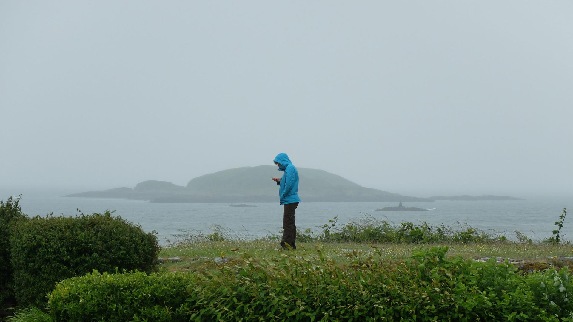A woman looks for a signal on the Isle of Coll, which is known for its near-total lack of cell phone coverage.