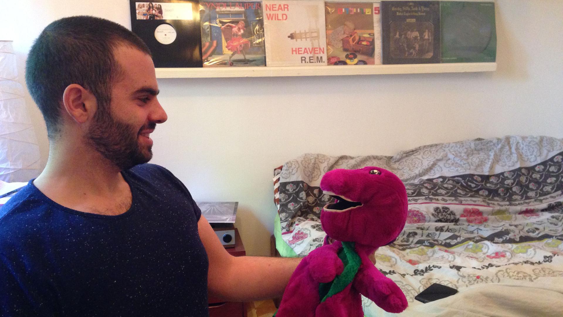Asaf Yusufov, who started the "Bernie in Hebrew" Facebook page, holds a Barney the Dinosaur that a friend gave him as a gag gift. (Bernie and Barney are spelled the same in Hebrew.)