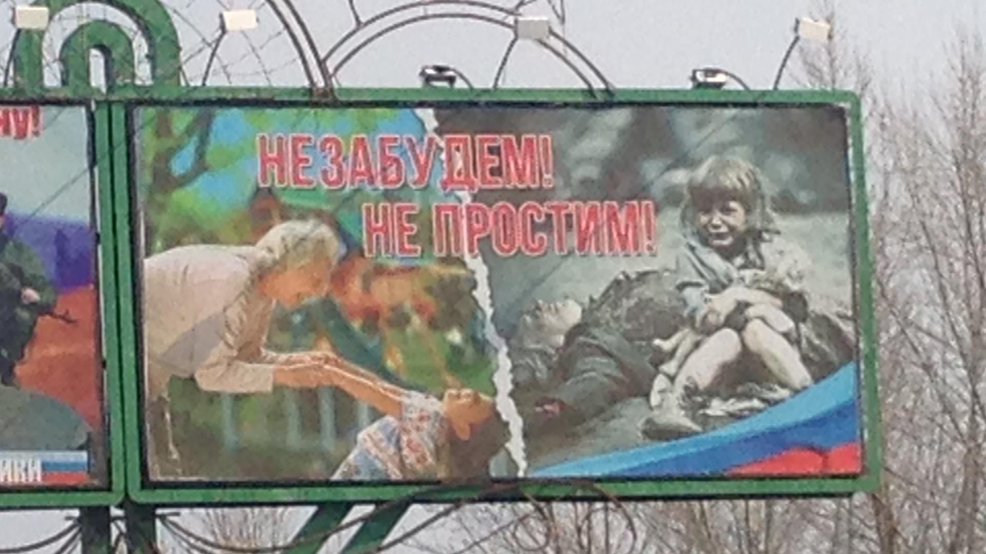 A manufactured story in Eastern Ukraine. The billboard reads, "We won't forget, we won't forgive," but Antelava says the photo of the girl has been faked.