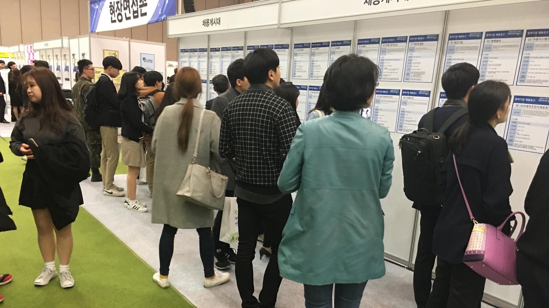 Young South Koreans check out job listings from small and medium sized firms at a jobs fair in Goyang. The government is considering offering subsidies to make these jobs more attractive to younger applicants.