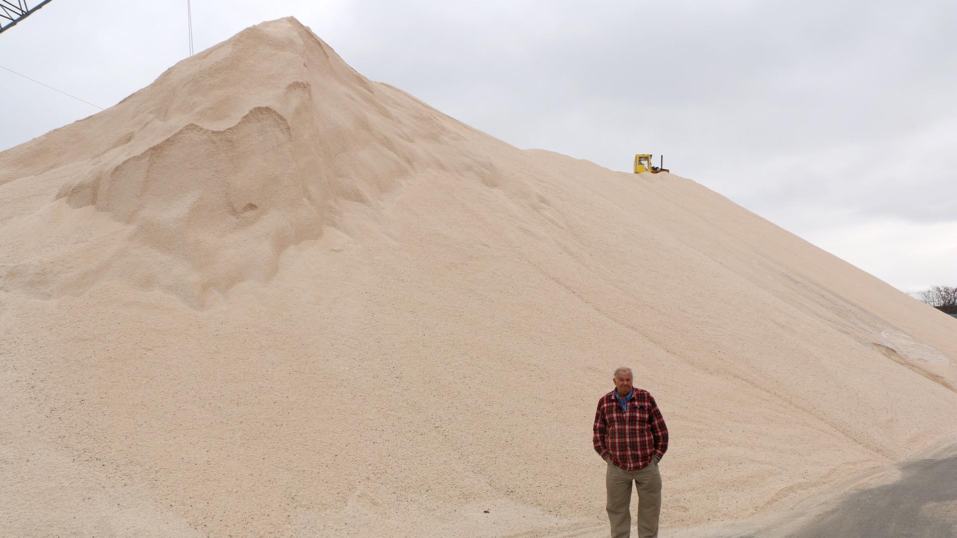 Terminal manager Paul Lamb stands before one of the piles of salt at Eastern Minerals, Inc. in Chelsea, Massachusetts. They bring in hundreds of thousands of pounds of salt every year.