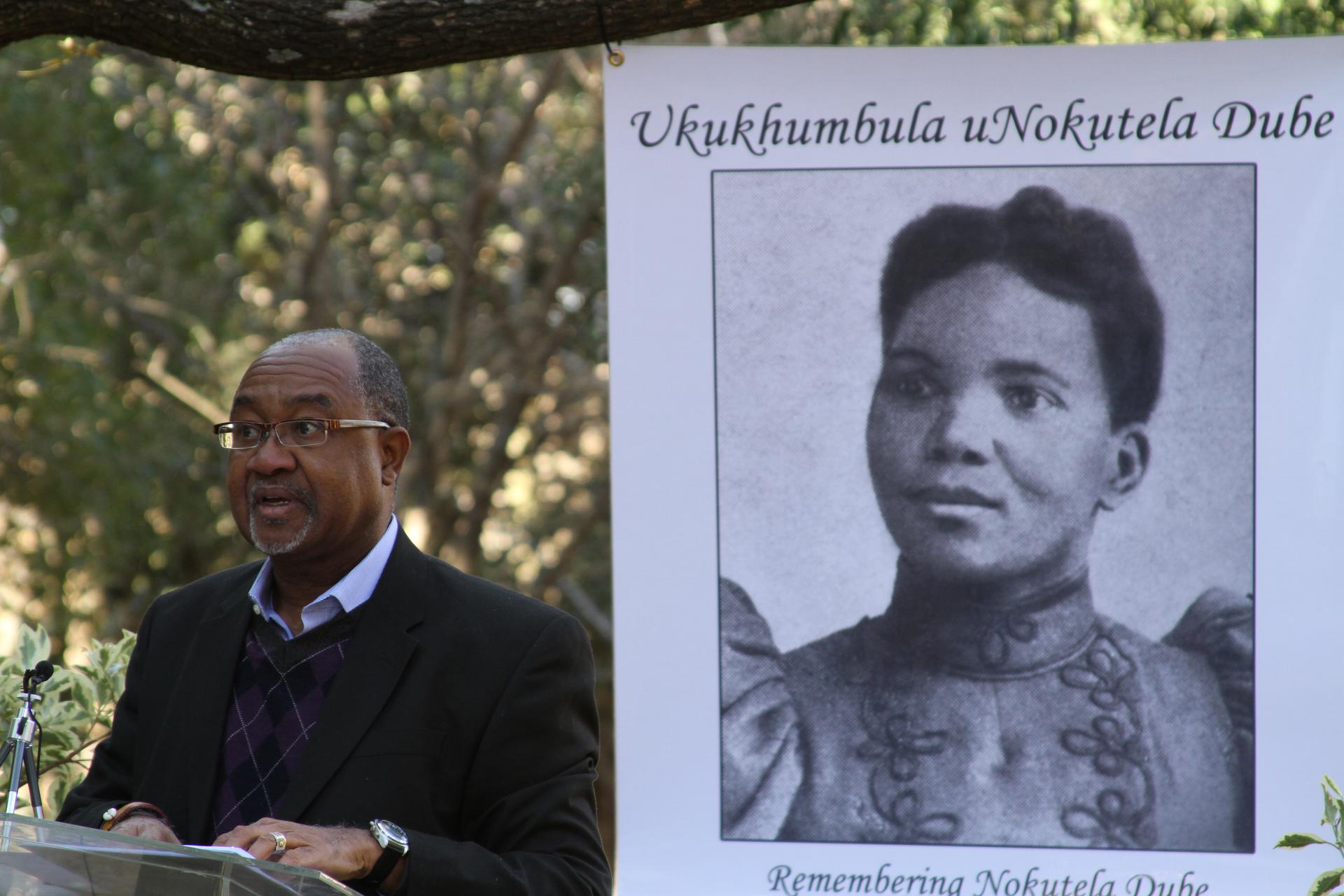 African scholar Cherif Keita of Carleton College next to a photo of  South African educator, journalist and political activist Nokutela Dube. Keita has produced a documentary about the wife of the founder of the African National Congress, called “Remember