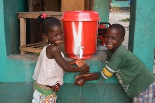 Children in Lower Johnsonville, Liberia, wash their hands