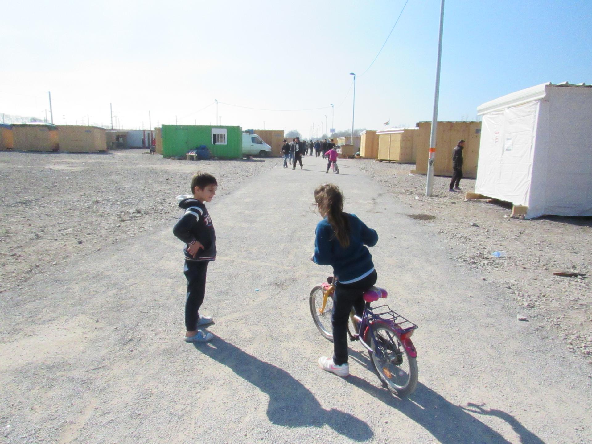 Children play on the main road at the new migrant camp in Grand-Synthe.