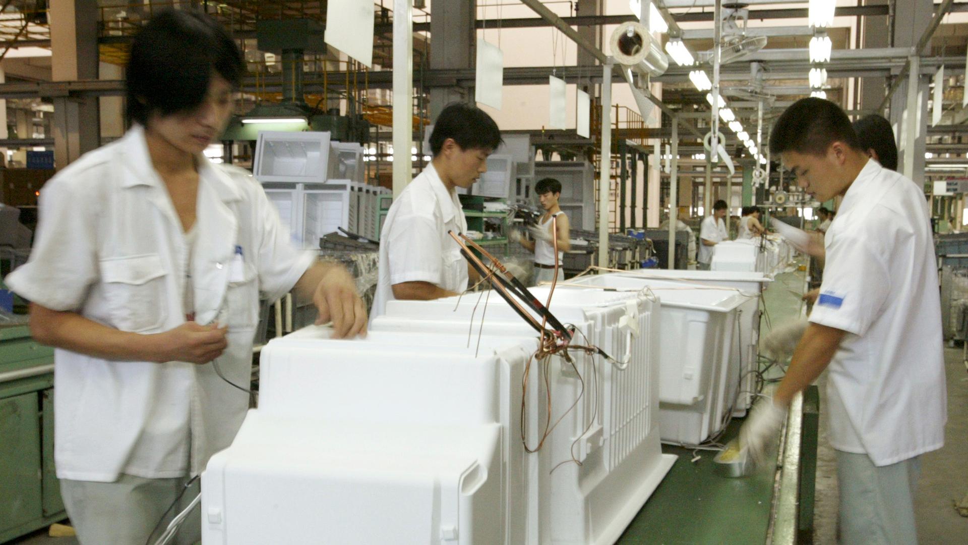 Chinese workers assemble a refrigerator in the eastern port city of Qinddao. A new study shows that for 15 products, Chinese manufacturing produces an average of 4.4 times the carbon emissions than if the products were made in the European Union.