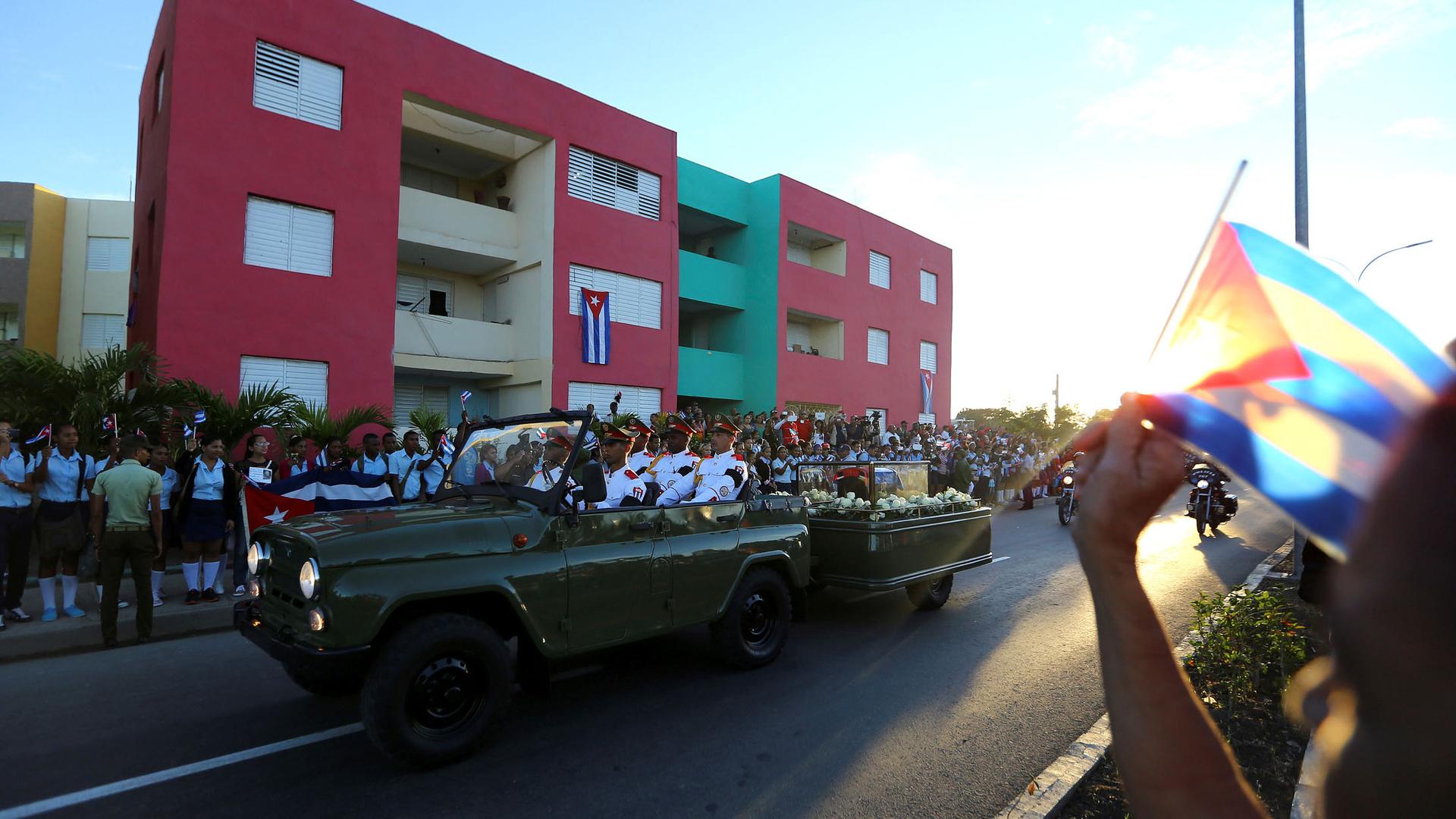 People watch the cortege carrying the ashes of Fidel Castro drive toward Santa Ifigenia cemetery in Santiago de Cuba. 
