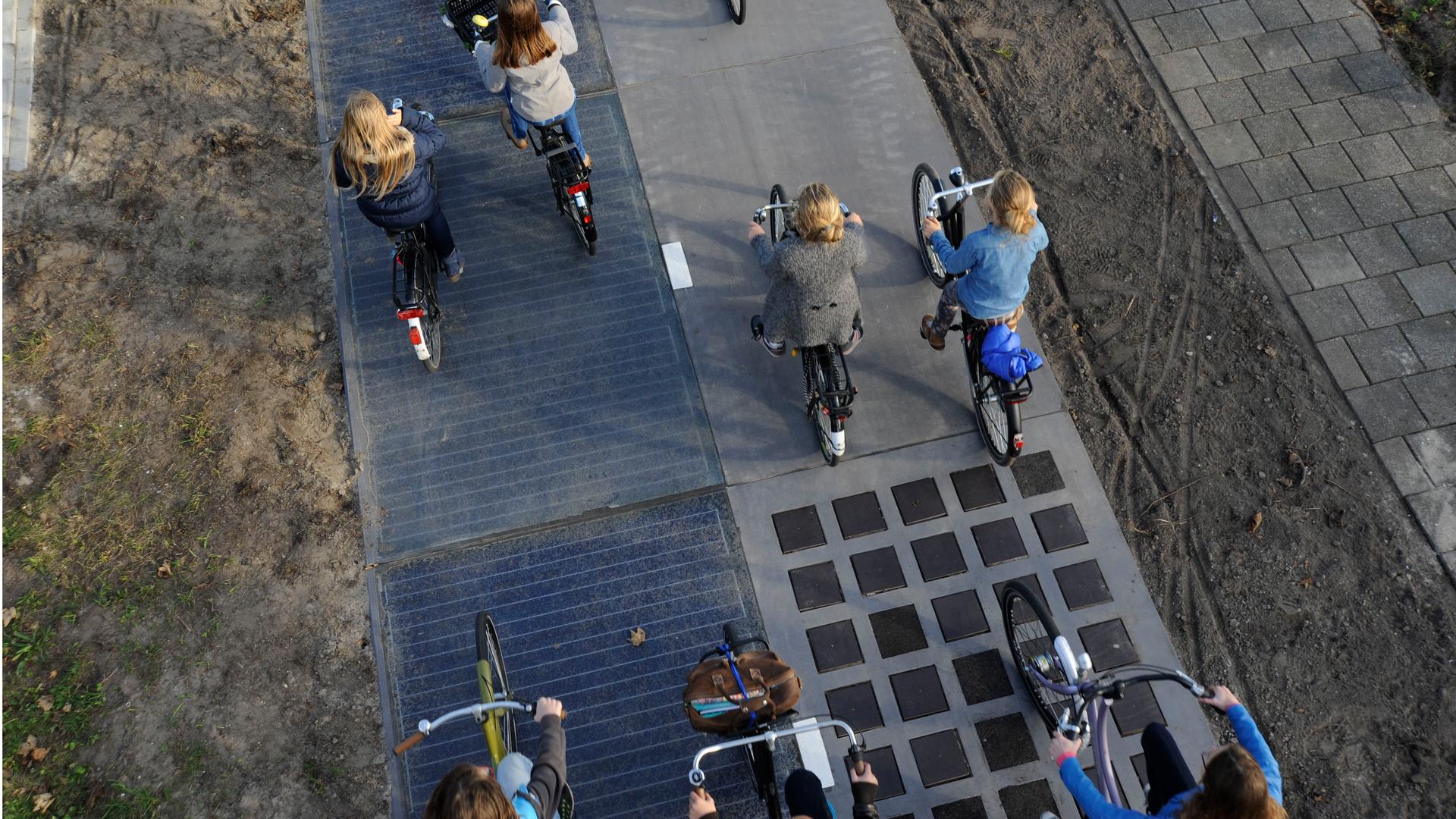 Cyclists ride over a 230 feet stretch of a new bike made entirely of solar panels in The Netherlands.