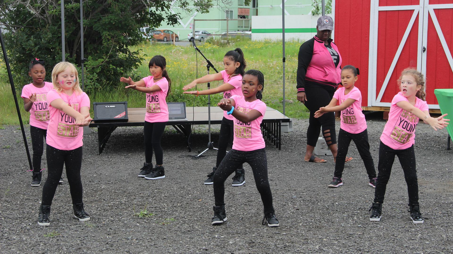 Girls with the “Rhythm of Light” dance troupe perform at a weekly farmer’s market in Anchorage’s Mountain View neighborhood. 