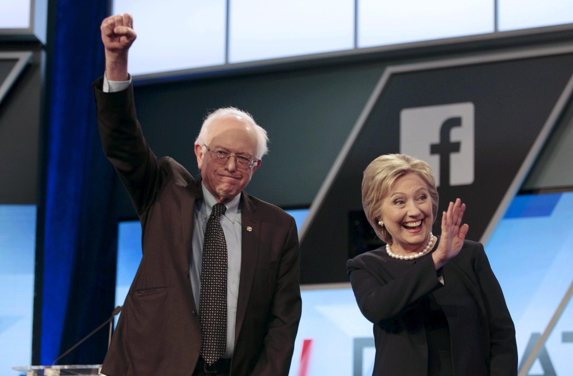 Democratic presidential candidates Senator Bernie Sanders and Hillary Clinton wave before the start of the Univision News and Washington Post Democratic debate in Kendall, Florida on March 9, 2016