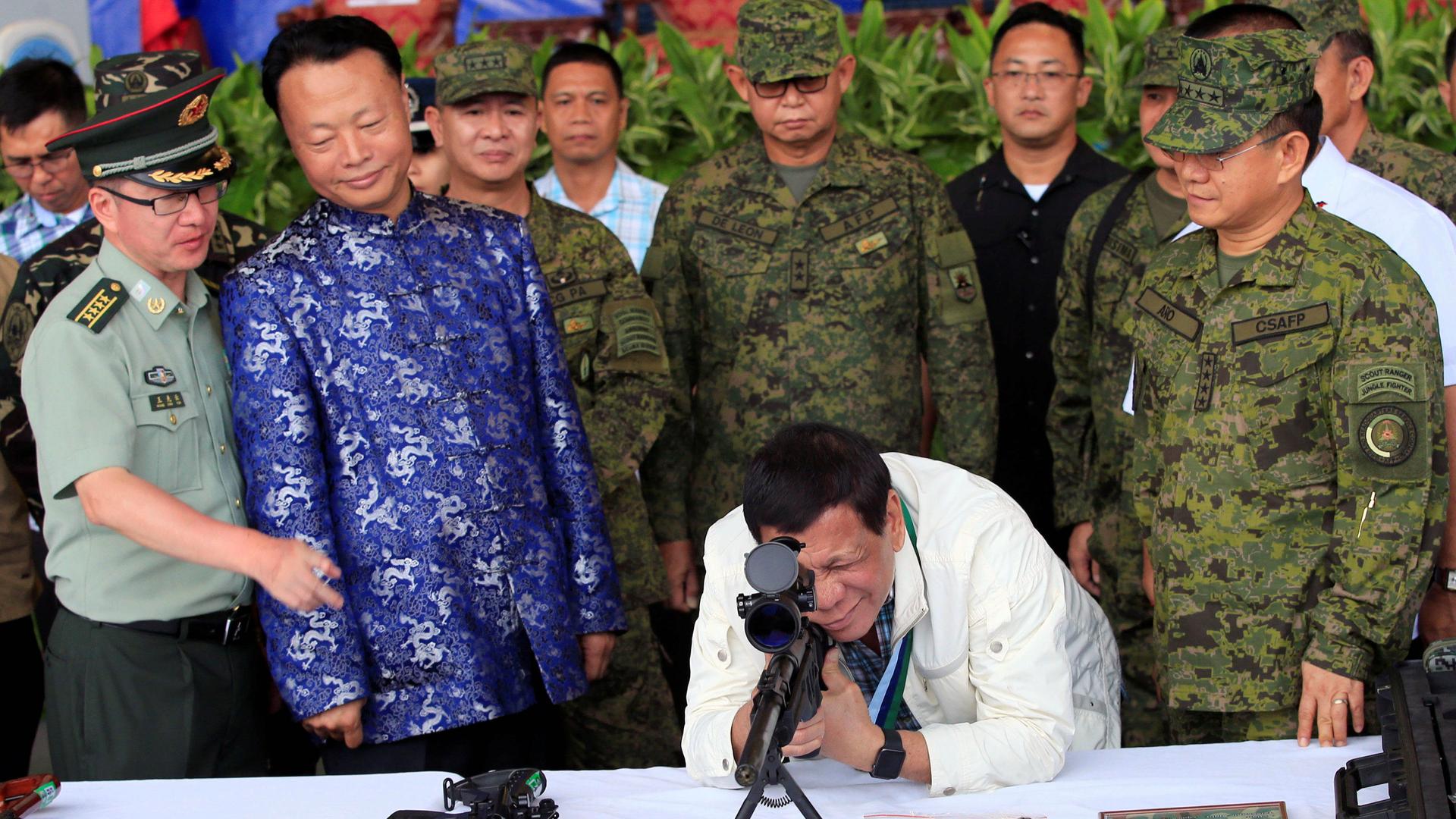 Philippine President Rodrigo Duterte checks the scope of a 7.62 mm sniper rifle