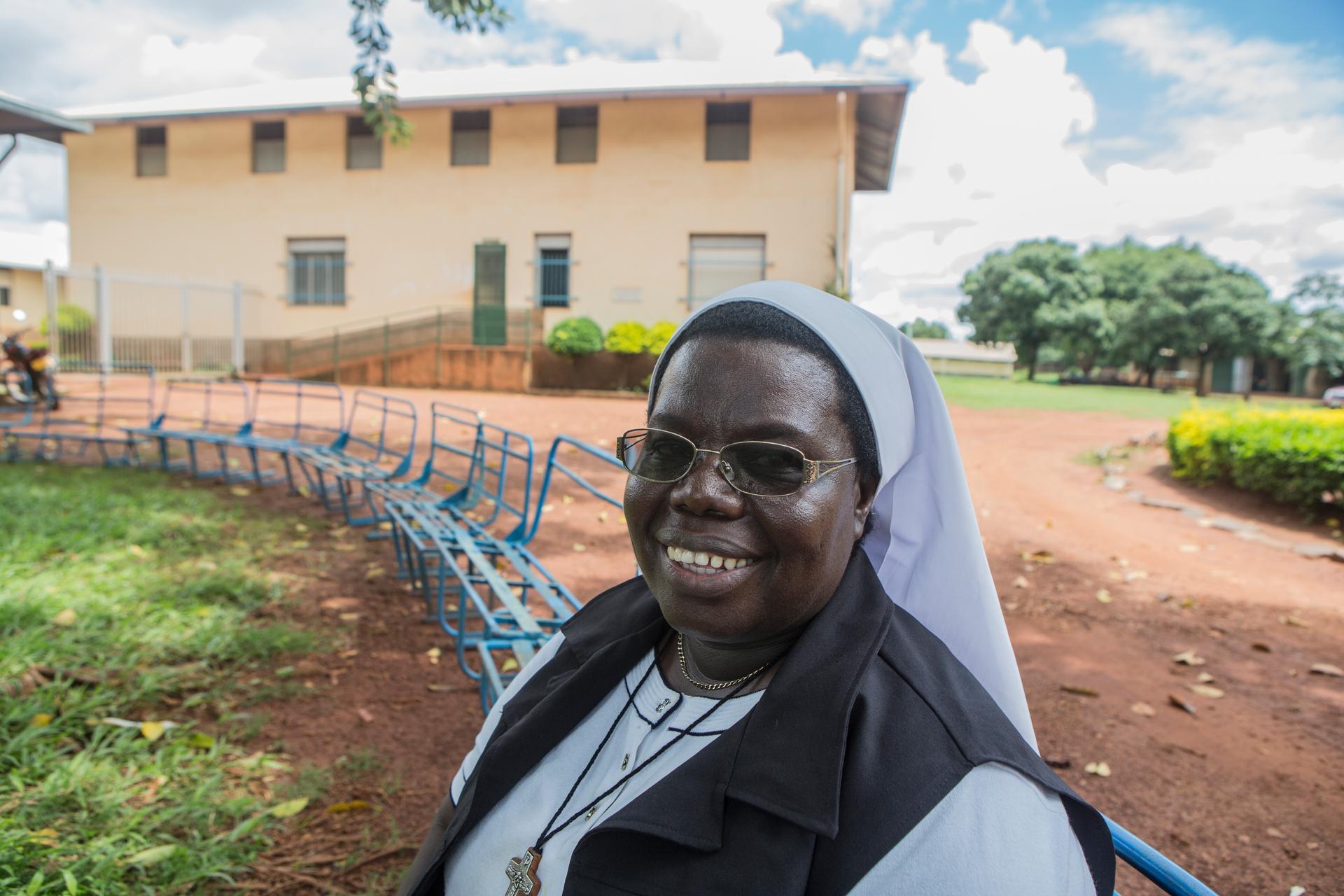 Sister Rosemary Nyirumbe sitting on a bench in front of St. Monica's Vocational School in Gulu, Uganda.