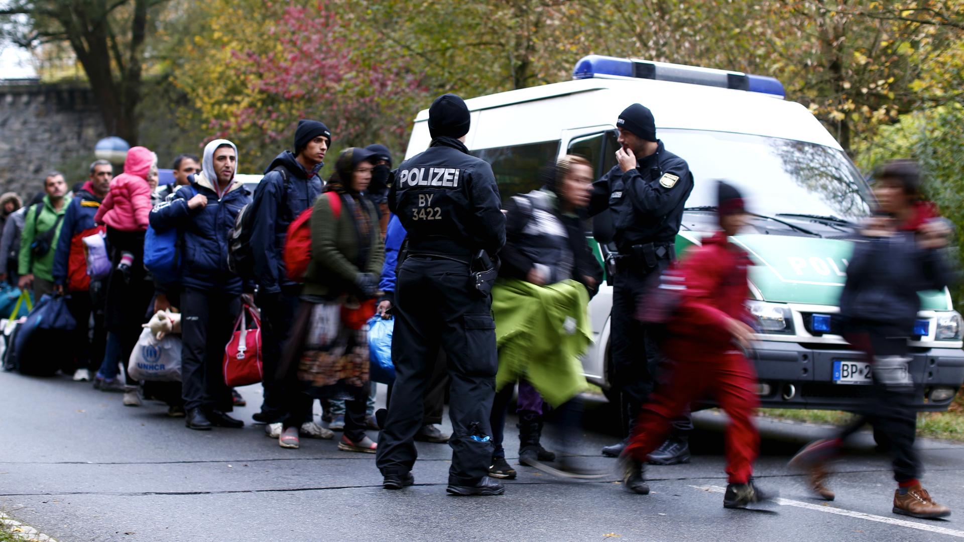 Newly arrived migrants are cleared by German police officers after crossing the Austrian-German border from Achleiten, Austria, into the city of Passau, Germany on October 29, 2015. 