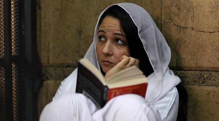 Aya Hijazi, founder of a nonprofit charity that looks after Egyptian street children, sat reading a book inside a holding cell as she faced trial in a courthouse in Cairo, Egypt on March 23.