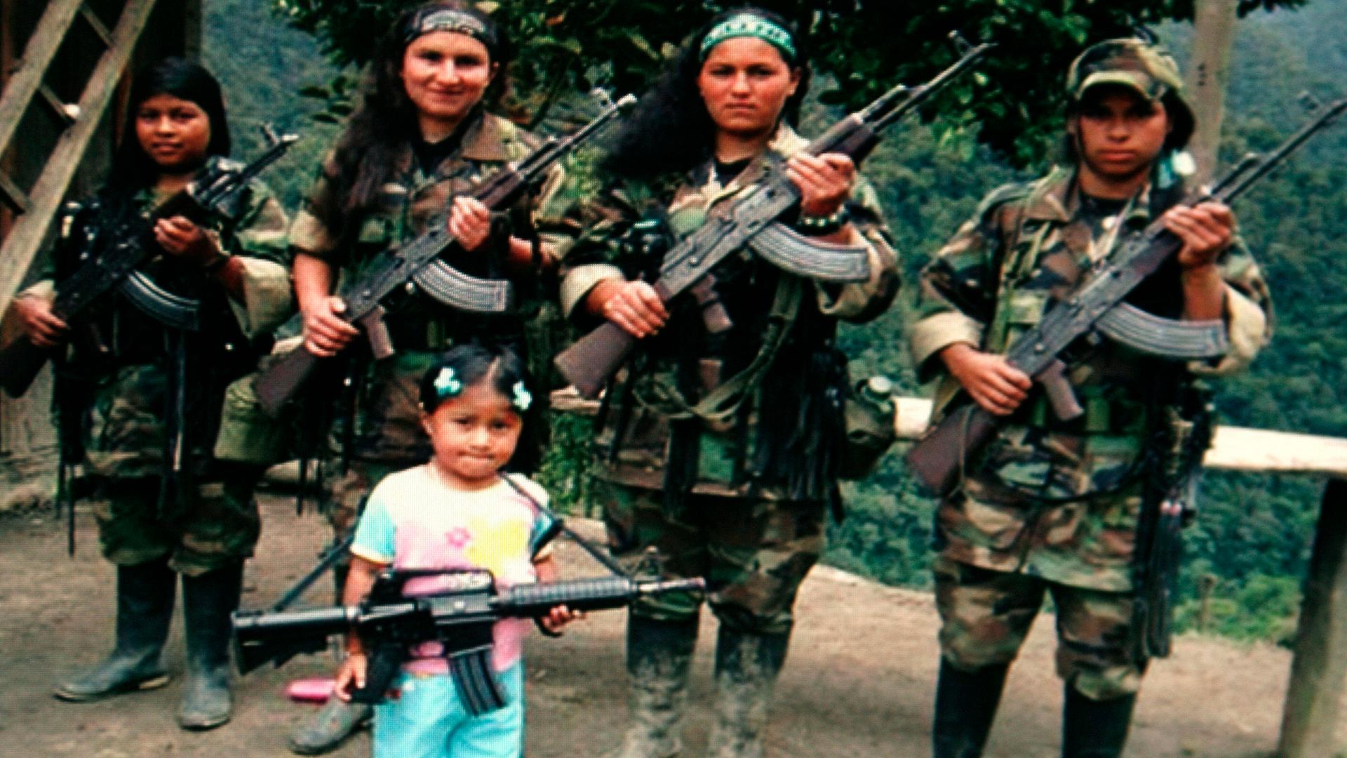 FARC rebels pose with an unidentified girl holding a weapon in southern Colombia in this undated photo confiscated by the Colombian police and released to the media on November 12, 2009. Police said that the photo was found on the body of a rebel FARC kil