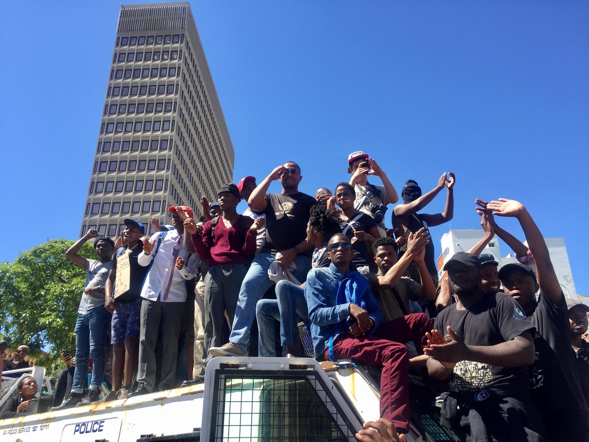 Protesters atop a police van in Cape Town last month