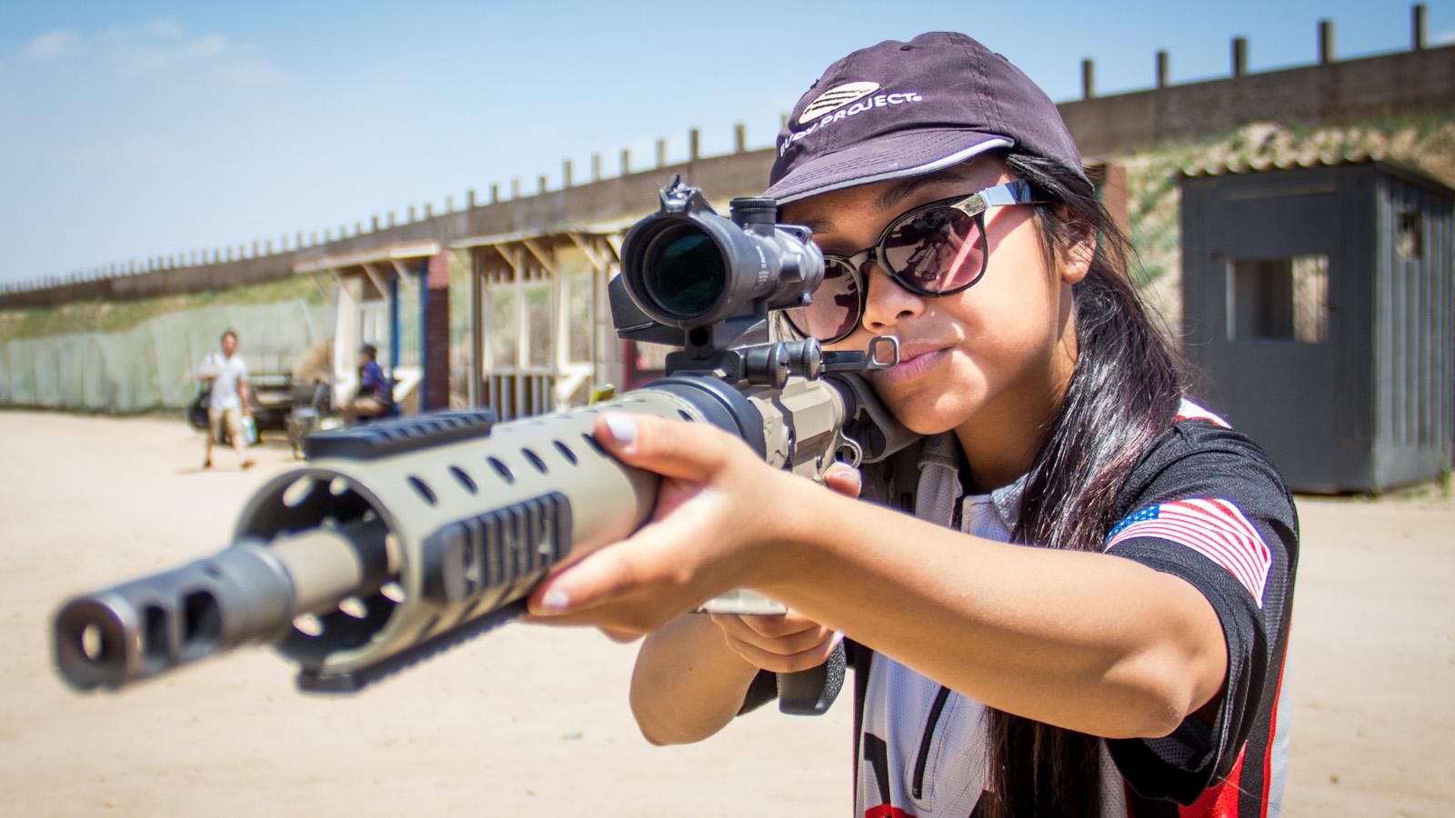 Claudia Vidanes aims a Phatom Strike AR-15, a custom gun designed by her father, Jojo Vidanes, who is the president of the Norco Running Gun Club in California.
