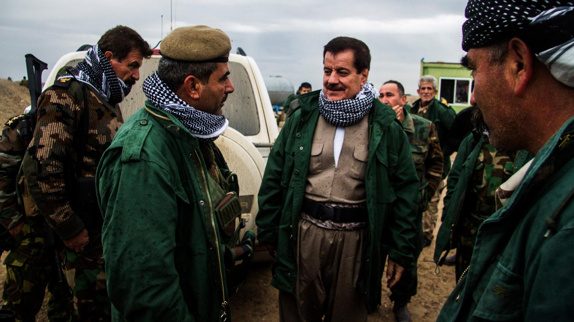 Kemal Kerkuki, commanding officer of Peshmerga forces outside of Kirkuk, speaks with his troops. 