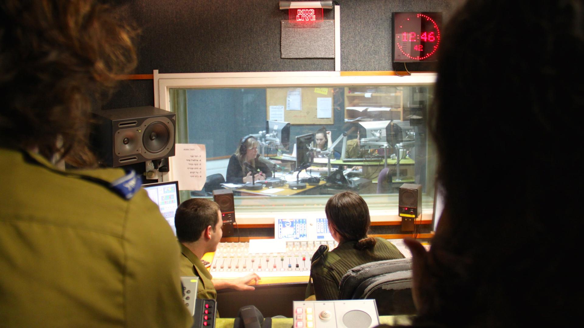 Soldiers in the production booth during a talk show at Galey Tzahal, Israel Army Radio’s news talk channel.