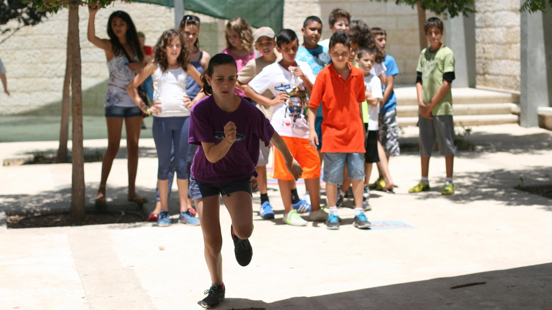 The kids at Project Harmony camp mostly do normal summer activities, like sports tournaments, as a way to get to know each other. Here, children compete in a jumping contest.