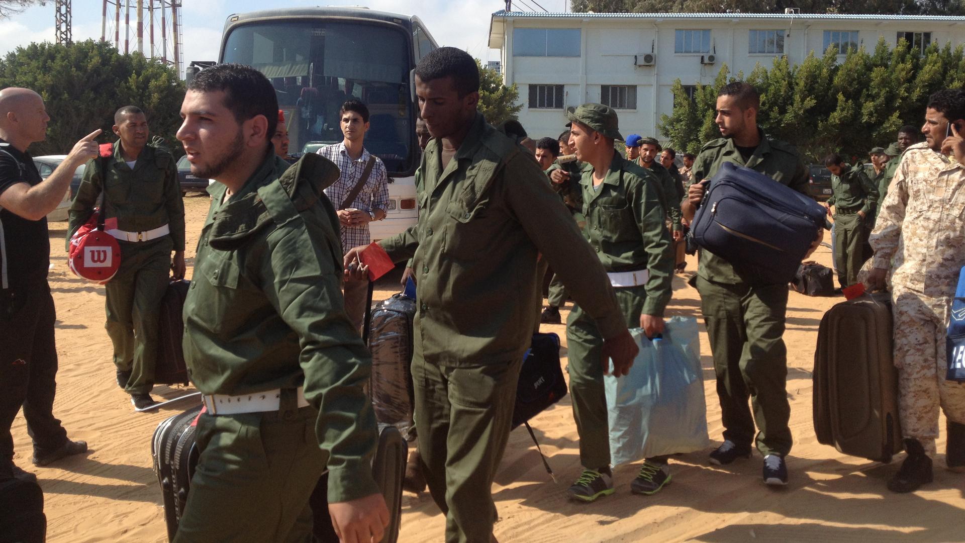 The soldiers arrive at the military airport in Tripoli on Tuesday morning.