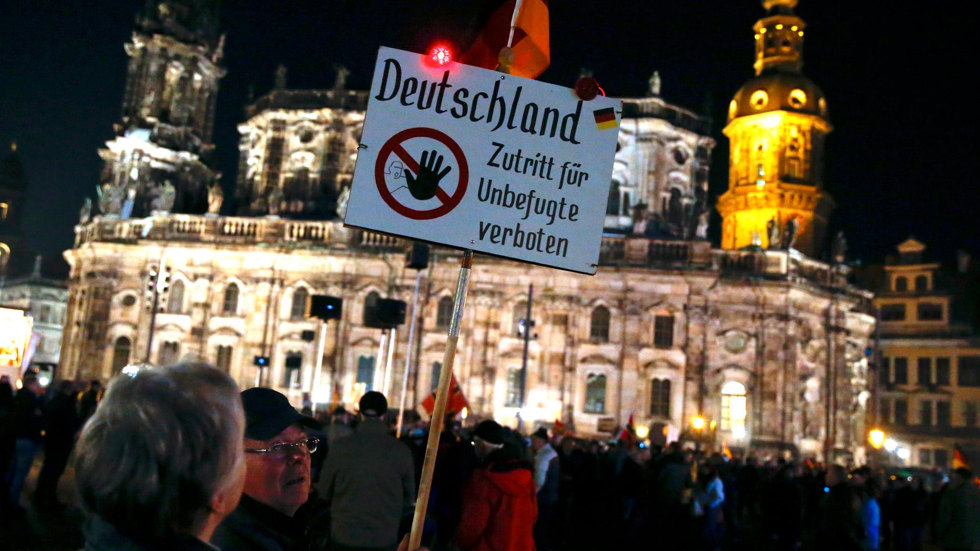 An elderly man attending one of the weekly Pegida protests in Dresden carries a sign reading, "Germany - Off limits to unauthorized,” on October 26, 2015.