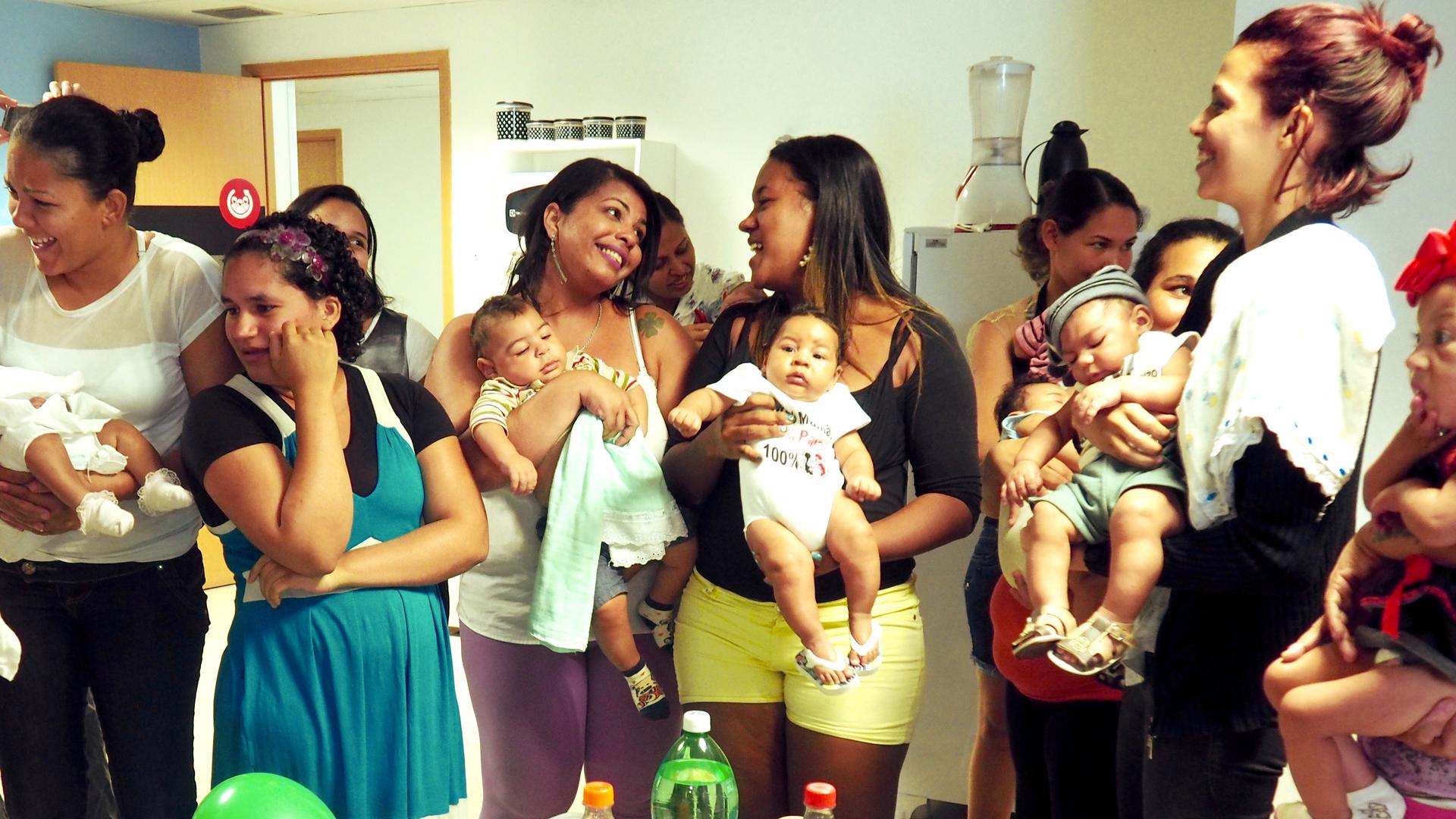 Elaine Marques, 29 (center left) smiles at Germana Soares, 24, at a group birthday party for babies born with microcephaly in Recife, Brazil.
